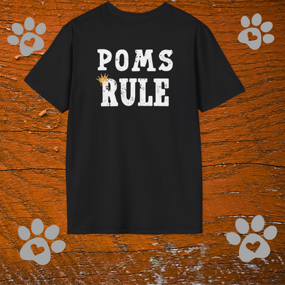 Black t-shirt with 'POMS RULE' text on a wooden background with paw prints.