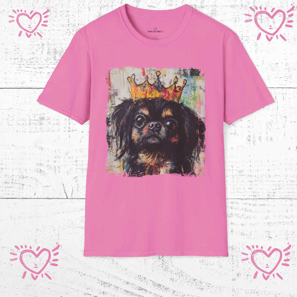 Pink t-shirt with a dog wearing a crown graphic on a white wooden background
