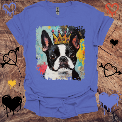 Blue t-shirt with a Boston Terrier  wearing a crown graphic on a wooden surface.