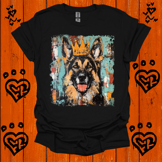 Black t-shirt with a german shepherd wearing a crown graphic on an orange wooden background with heart designs.